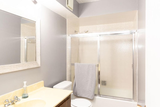 full bathroom featuring toilet, visible vents, bath / shower combo with glass door, and vanity