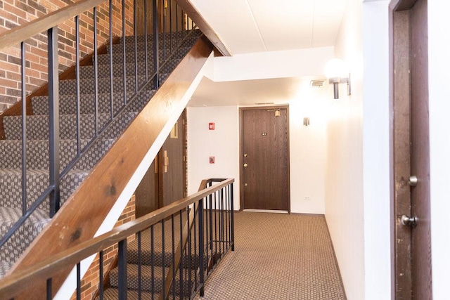 stairway with visible vents and carpet floors