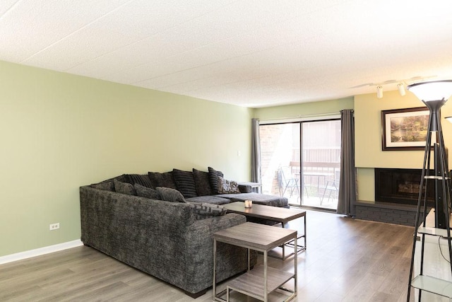 living area with baseboards and wood finished floors
