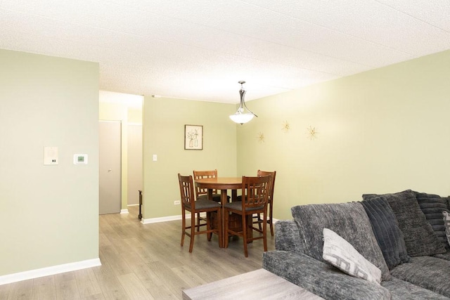 dining area with light wood finished floors and baseboards