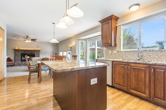 1518 Parkside Dr, Plainfield, IL 60586 - kitchen with light wood-style flooring, a fireplace, a sink, and decorative light fixtures