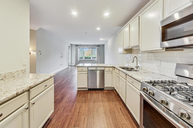 2640 Summit Dr Unit 110, Glenview, IL 60025 - kitchen featuring appliances with stainless steel finishes, backsplash, dark wood-style flooring, a sink, and a peninsula