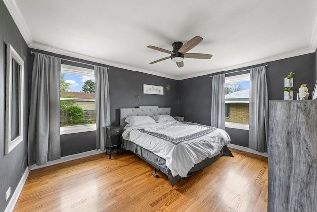 bedroom with ornamental molding, multiple windows, and light wood-style flooring