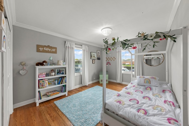 bedroom featuring crown molding, multiple windows, and light wood finished floors