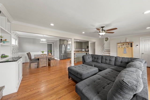 living room with ceiling fan, crown molding, stairway, light wood-style floors, and recessed lighting