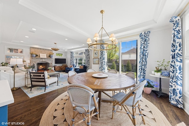 236 W Crescent Ave, Elmhurst, IL 60126 - dining area with a raised ceiling, dark wood-style floors, a chandelier, a stone fireplace, and ornamental molding