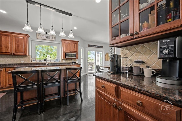 6N372 E Ridgewood Dr, Saint Charles, IL 60175 - kitchen with stainless steel microwave, decorative backsplash, brown cabinetry, recessed lighting, and glass insert cabinets