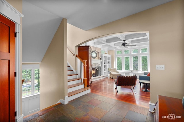 5900G Red Gate Ln, Yorkville, IL 60560 - living area with ceiling fan, a stone fireplace, arched walkways, coffered ceiling, and beamed ceiling
