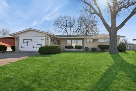 single story home featuring concrete driveway, a front yard, and an attached garage