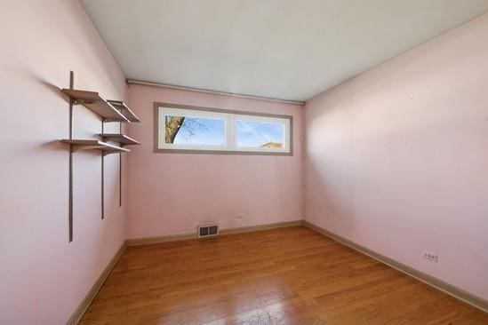 unfurnished room featuring baseboards, visible vents, and light wood finished floors