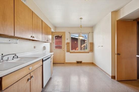 kitchen featuring light countertops, dishwasher, a sink, baseboards, and visible vents