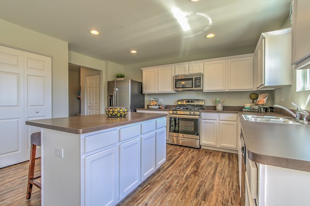 kitchen featuring dark countertops, a sink, white cabinets, and appliances with stainless steel finishes