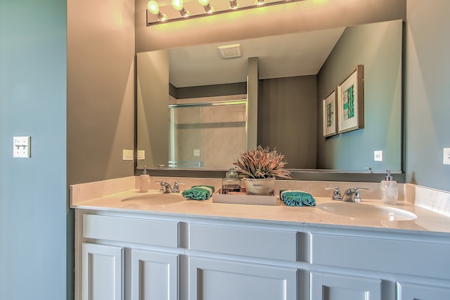 full bath with double vanity, a sink, and a shower stall