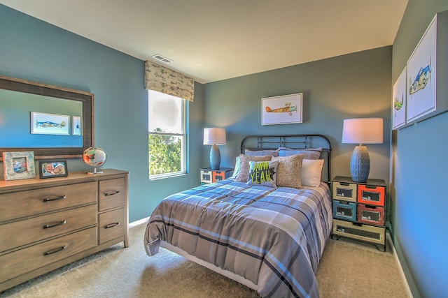 bedroom featuring visible vents, baseboards, and light carpet