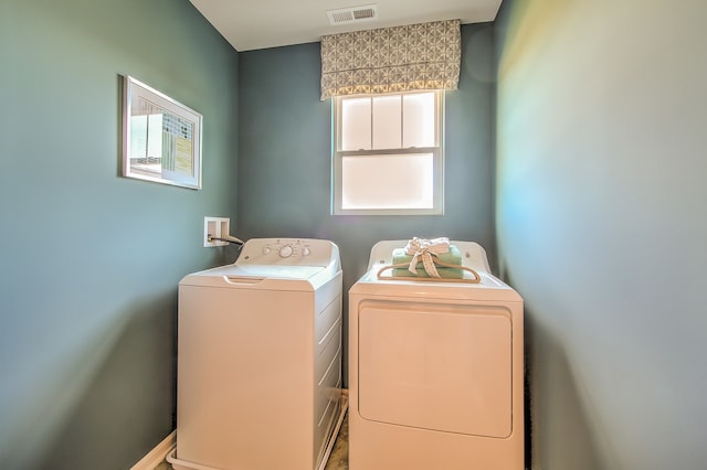 laundry area with visible vents, washing machine and clothes dryer, and laundry area