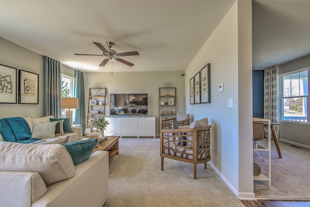 carpeted living area with baseboards, visible vents, and a ceiling fan