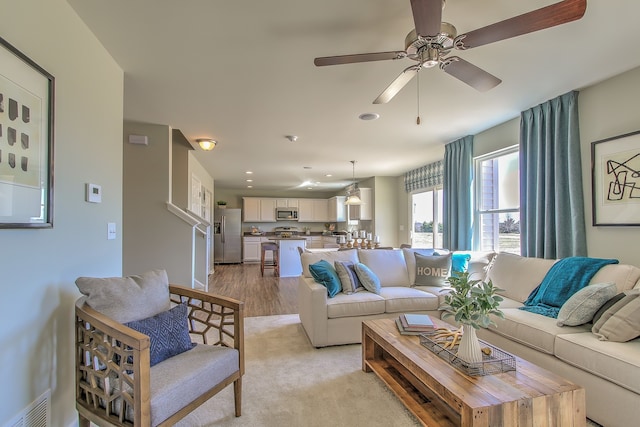 living area with visible vents, a ceiling fan, light wood-style flooring, and recessed lighting
