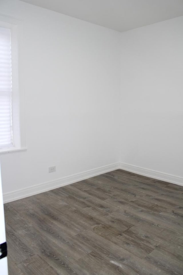 empty room with baseboards and dark wood-style floors