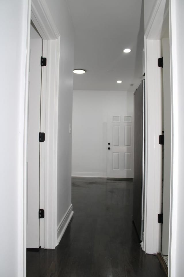 corridor featuring baseboards, recessed lighting, and dark wood-style floors