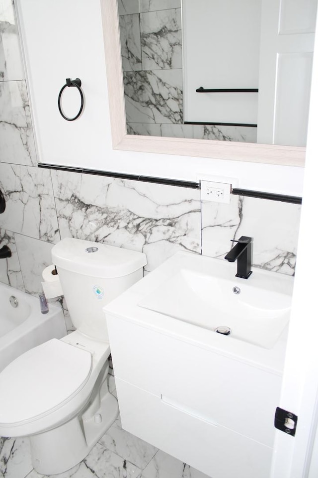bathroom featuring tile walls, bathtub / shower combination, vanity, toilet, and marble finish floor