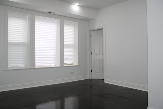 empty room with baseboards and visible vents