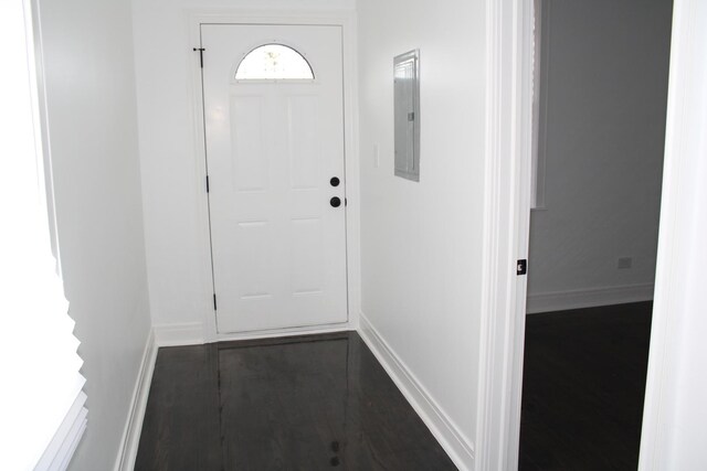 doorway featuring baseboards and electric panel