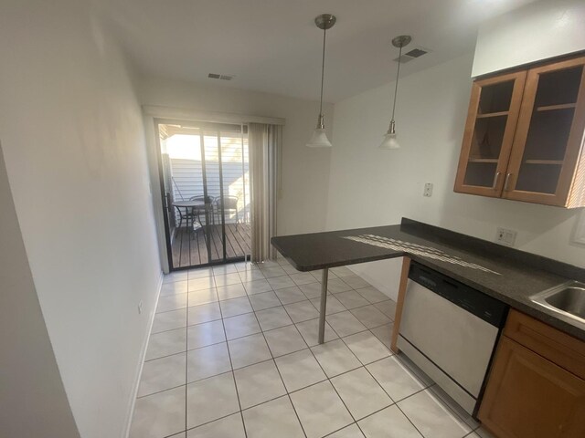 kitchen featuring dark countertops, light tile patterned flooring, visible vents, and dishwasher