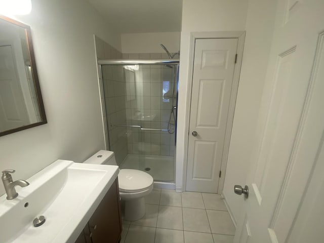 bathroom with toilet, tile patterned flooring, a shower stall, and vanity