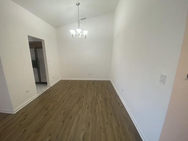 unfurnished dining area with lofted ceiling, dark wood-style flooring, a chandelier, and baseboards