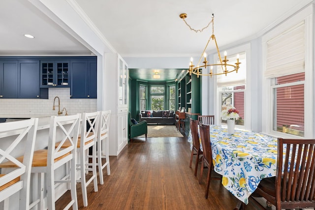 dining room featuring crown molding, an inviting chandelier, and dark wood finished floors