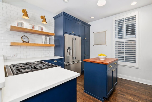 kitchen with blue cabinetry, wood counters, dark wood finished floors, decorative backsplash, and high quality fridge