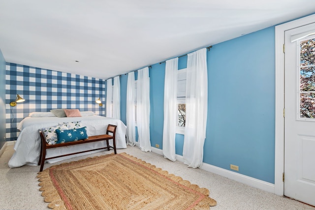 carpeted bedroom featuring baseboards and wallpapered walls