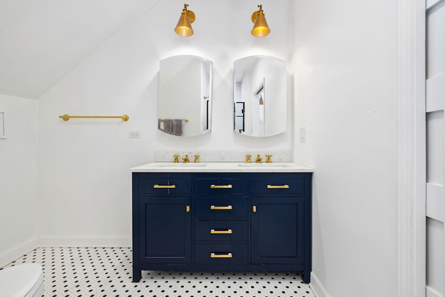 bathroom featuring baseboards, a sink, and double vanity
