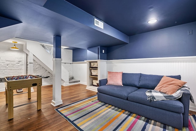living room featuring visible vents, wood finished floors, and a wainscoted wall