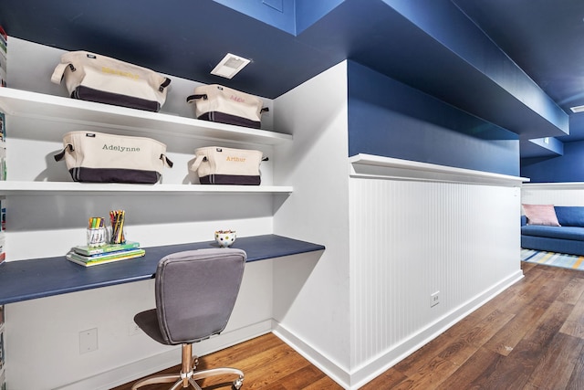 office space with built in study area, baseboards, and wood finished floors
