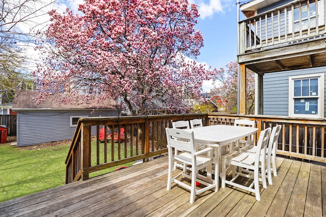 wooden deck with a lawn and outdoor dining space