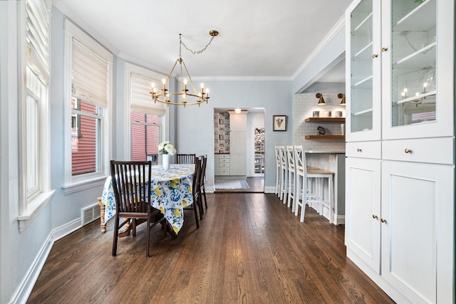 dining area with a chandelier, baseboards, dark wood-type flooring, visible vents, and ornamental molding