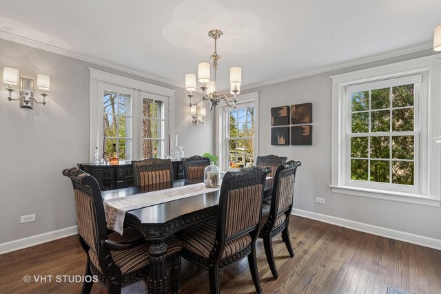 dining room featuring a chandelier, healthy amount of natural light, baseboards, and ornamental molding