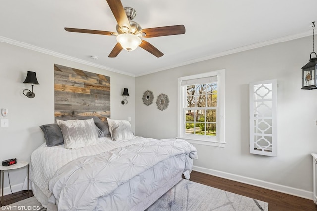bedroom with ornamental molding, baseboards, wood finished floors, and ceiling fan