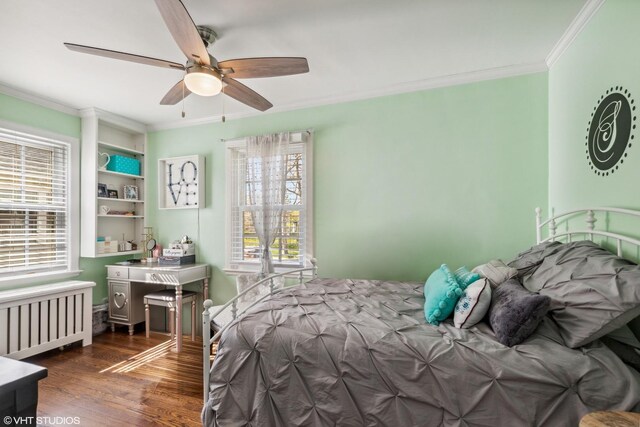 bedroom featuring radiator heating unit, ornamental molding, multiple windows, wood finished floors, and a ceiling fan