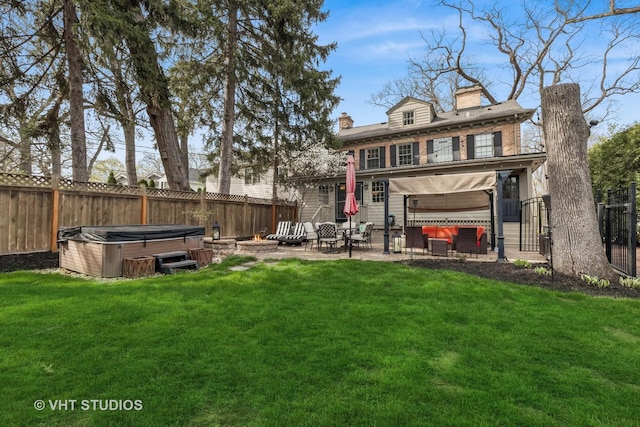 back of property with a hot tub, a patio, a chimney, and an outdoor hangout area