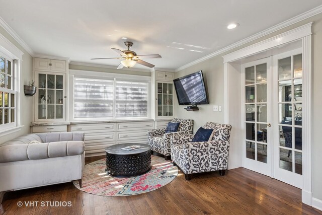 living area featuring wood finished floors, ceiling fan, and crown molding