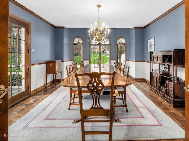 dining area with crown molding, baseboards, a notable chandelier, and a wealth of natural light