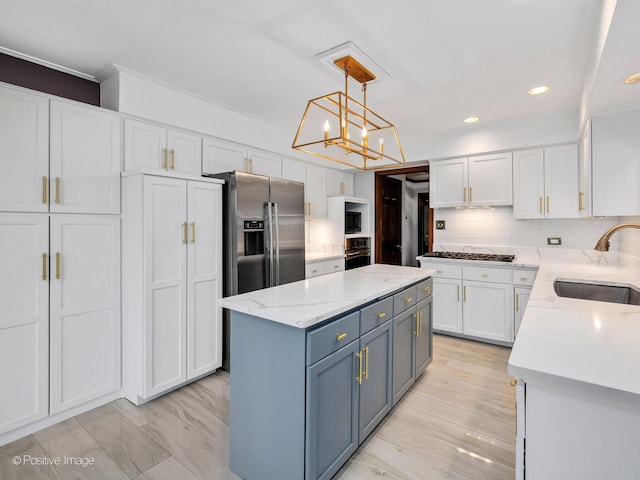 kitchen with oven, a sink, a chandelier, white cabinetry, and stainless steel refrigerator with ice dispenser