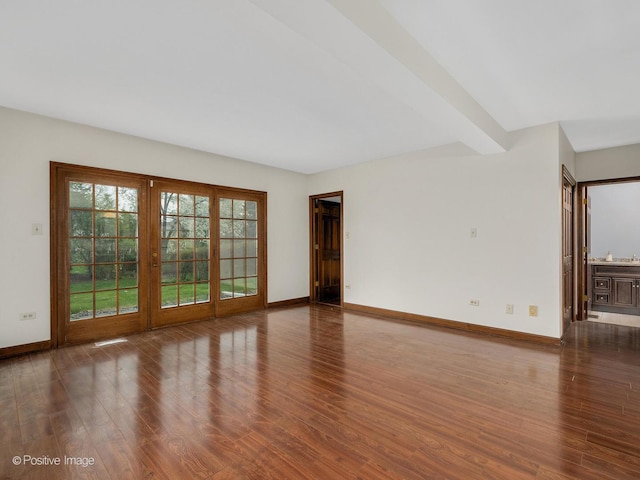 unfurnished living room with baseboards and wood finished floors