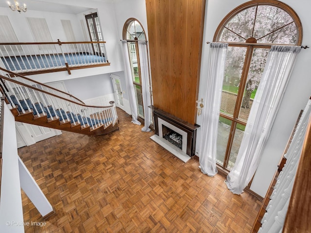 unfurnished living room with a healthy amount of sunlight, baseboards, and stairway