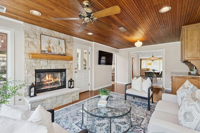 living room featuring wood ceiling, ceiling fan, a fireplace, and baseboards