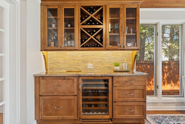 bar with indoor bar, backsplash, beverage cooler, and wood finished floors