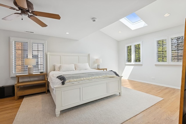 bedroom featuring vaulted ceiling with skylight, recessed lighting, ceiling fan, and light wood finished floors