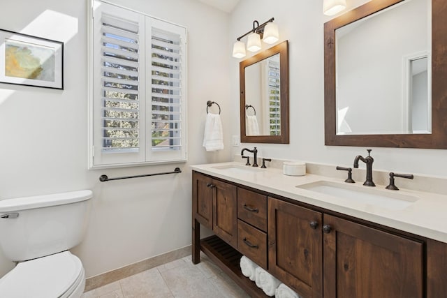 full bath featuring baseboards, a sink, tile patterned flooring, and toilet
